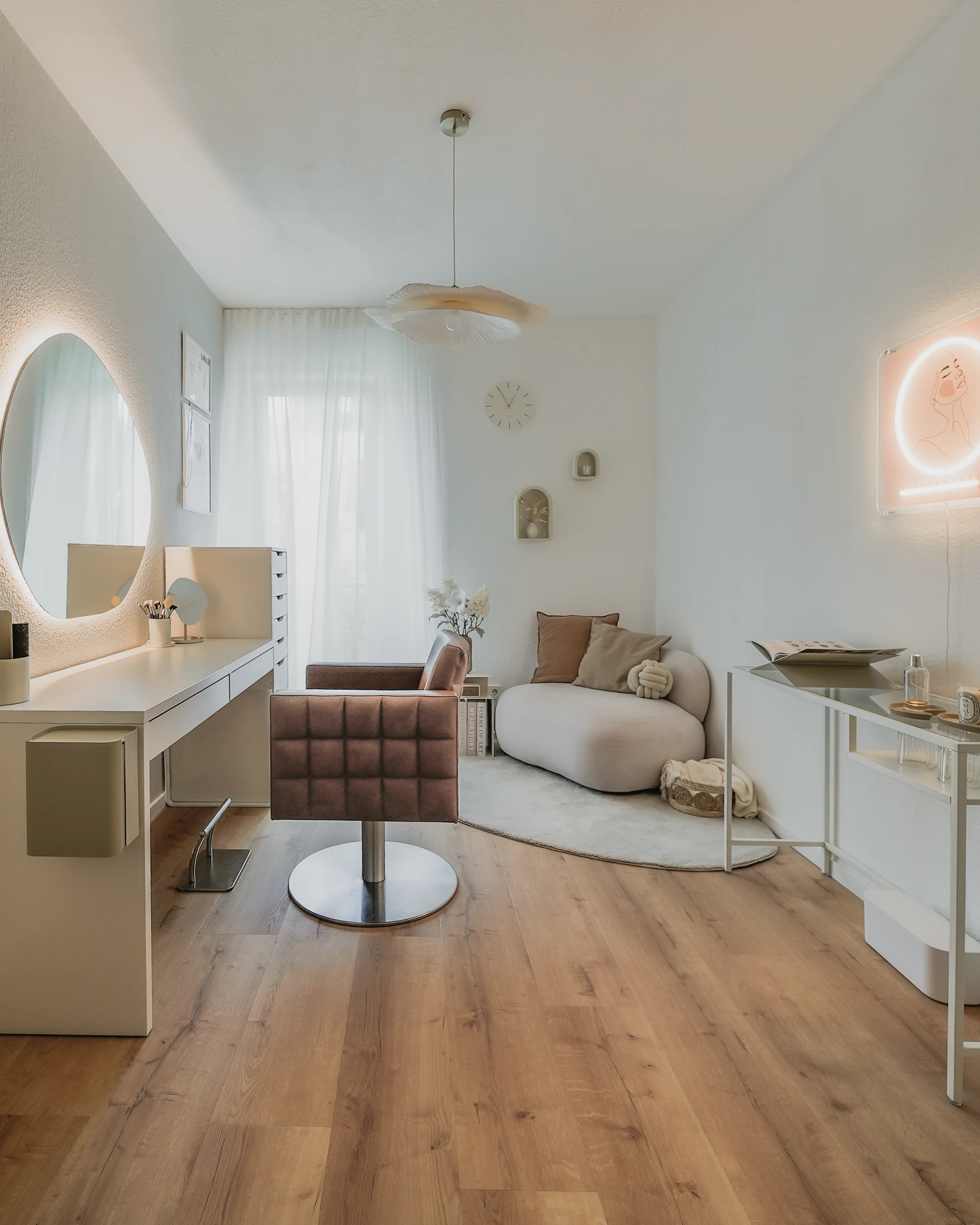Blick durch das helle Studio auf Stylingstuhl und Sitzecke.